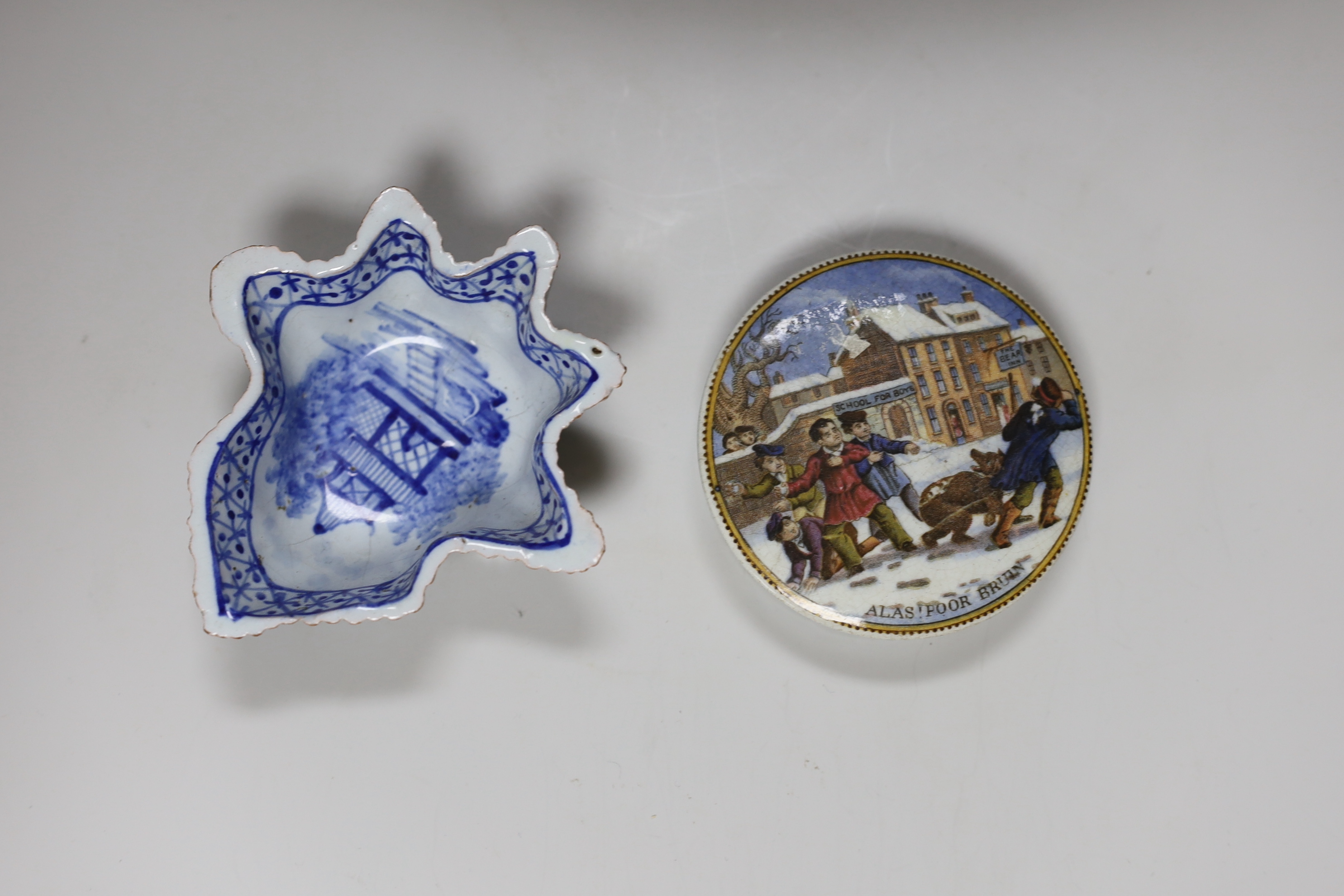 A collection of early 19th century pottery including a good sparrowbeak jug painted with flowers, a vase with blue decoration, a tea canister printed with birds in blue, a leaf shaped dish printed in blue, a pot lid and